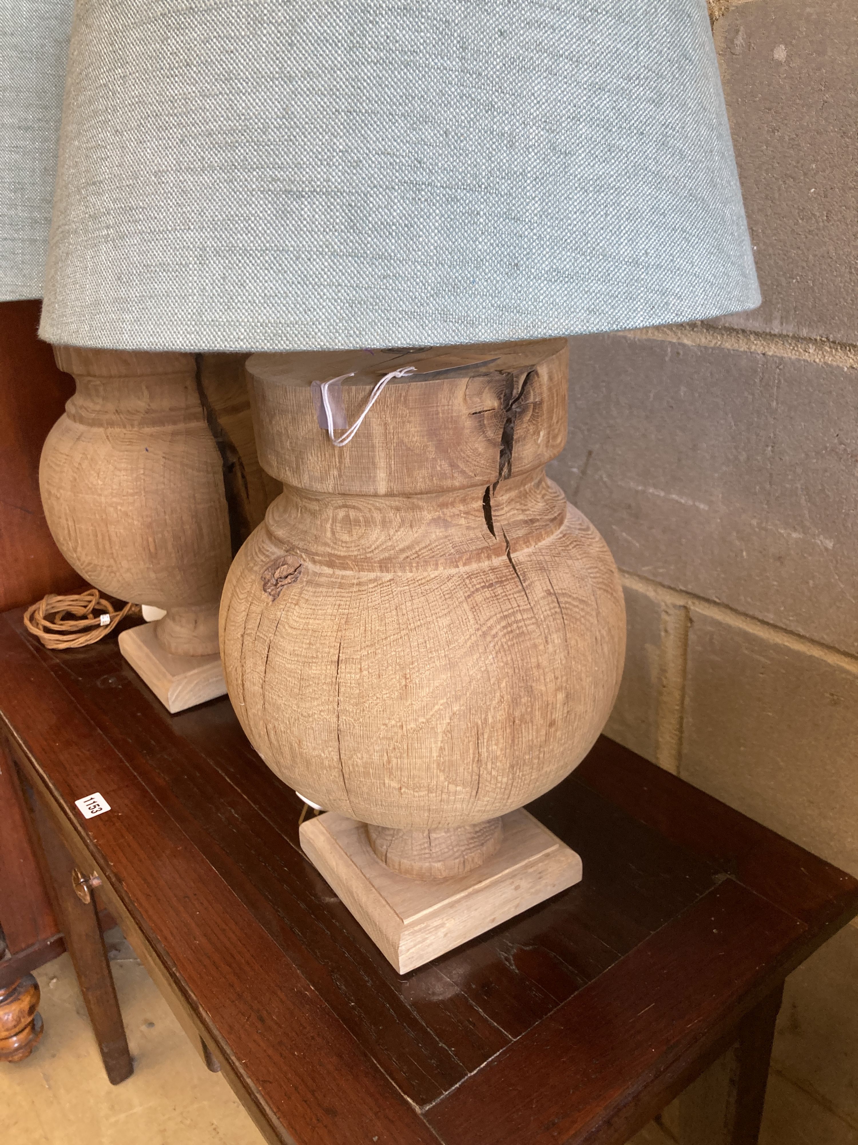 A pair of contemporary turned oak table lamps with shades, height 70cm